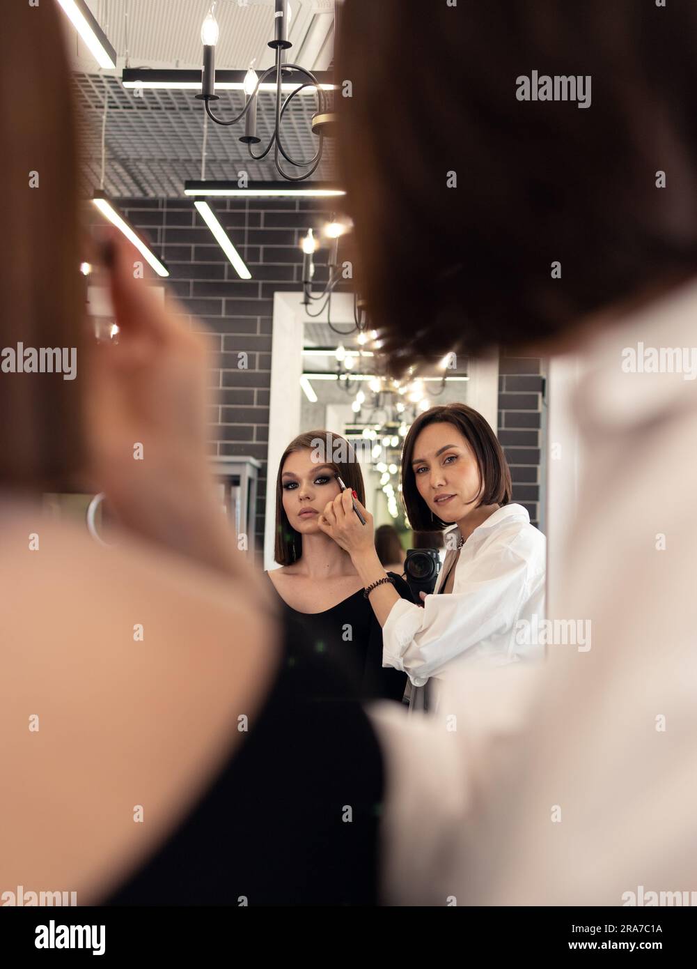 make-up artist makes-up in a beauty salon in front of a mirror Stock Photo