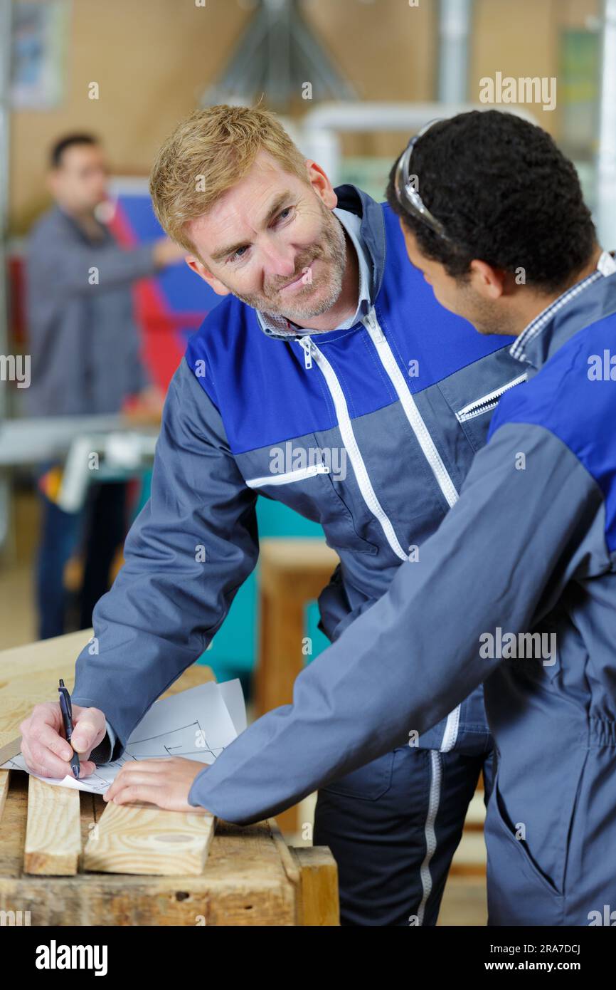 carpenter with apprentice in training period Stock Photo