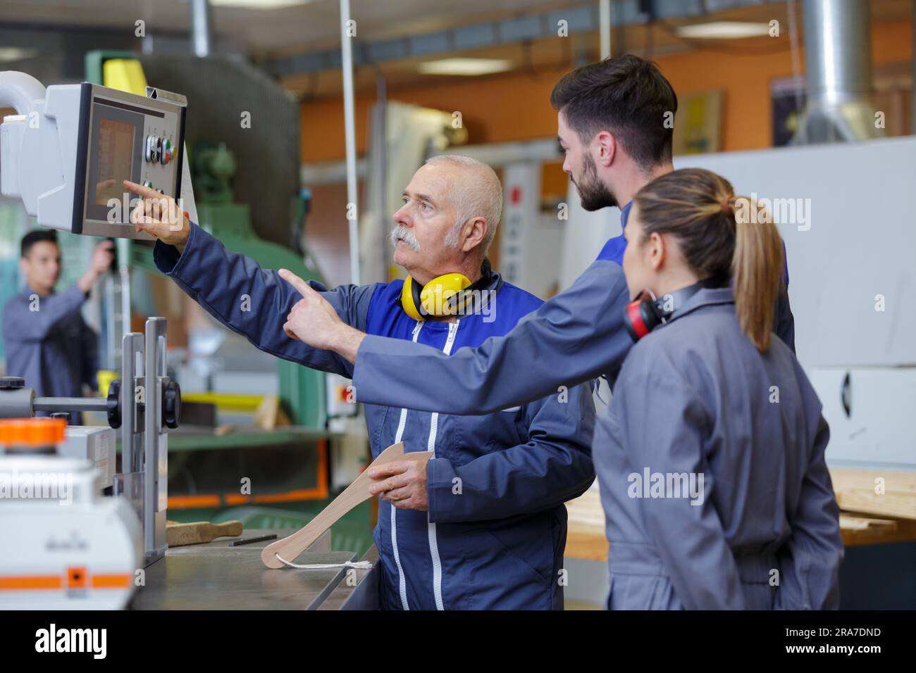 engineer and apprentice using automated machinery Stock Photo