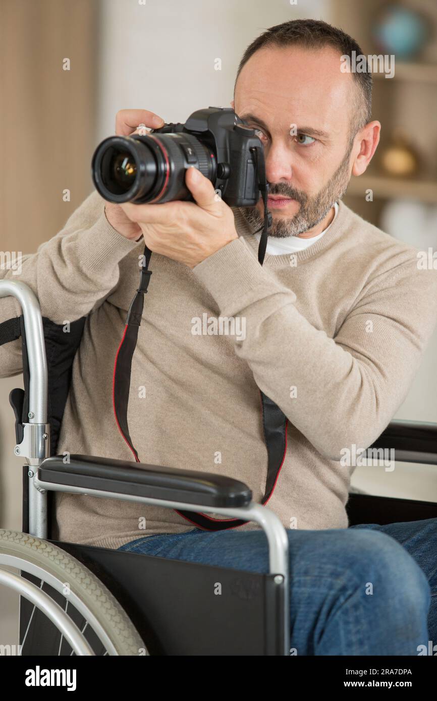 mature disabled photographer focusing camera Stock Photo