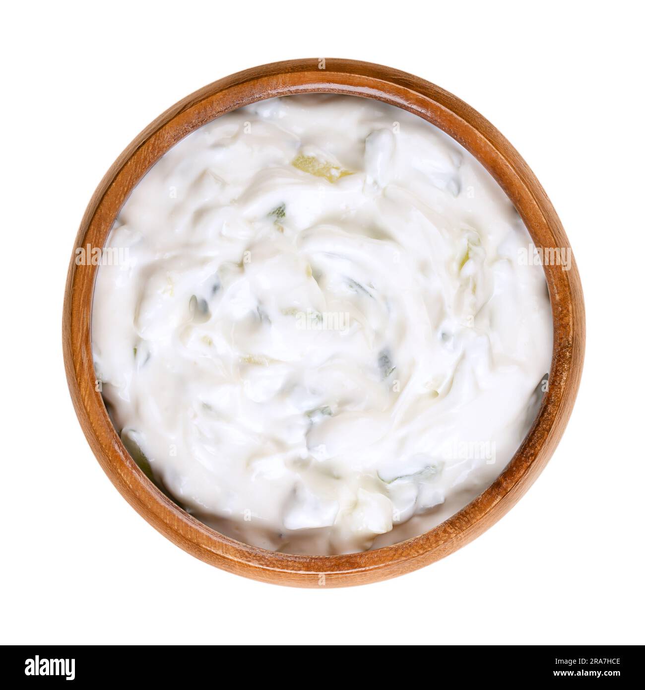 Tzatziki, in a wooden bowl. Fresh Greek dip sauce, served as an appetizer (meze) or side dish, and made of strained yogurt. Stock Photo