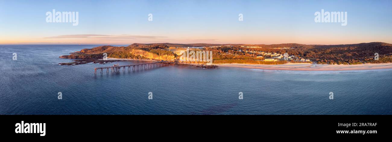 Waterfront of Catherine Hill bay Middle Camp beach from Pacific ocean in aerial panorama from Pacific ocean at sunrise. Stock Photo