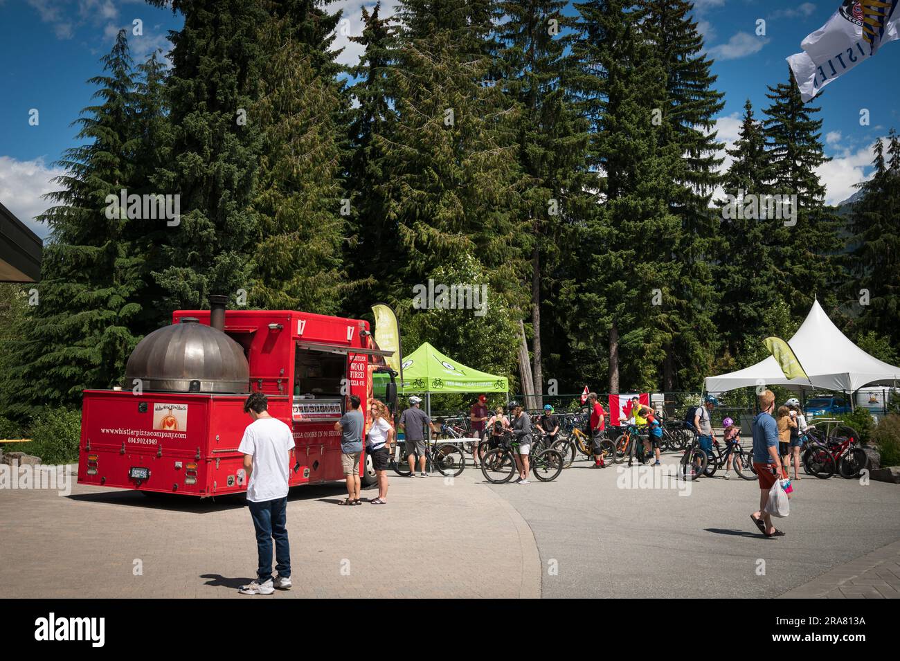 Tourists in the Whistler Village with a food truck on Canada Day, 2023.  Whistler BC, Canada. Stock Photo