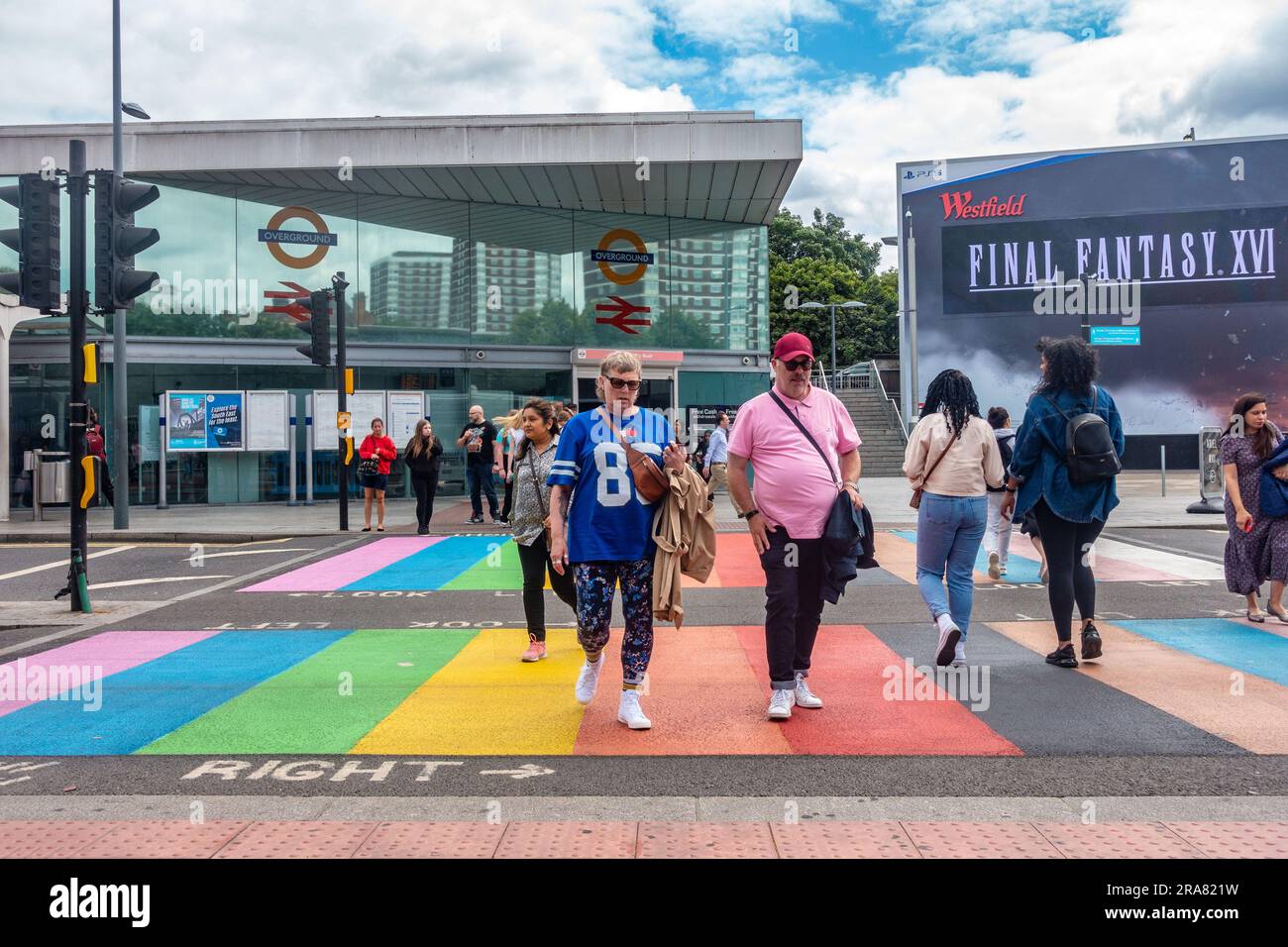 People cross the road via a colourful pedestrian crossing painted in the rainbow colours which are synonymous with the LGBQT community in London Stock Photo