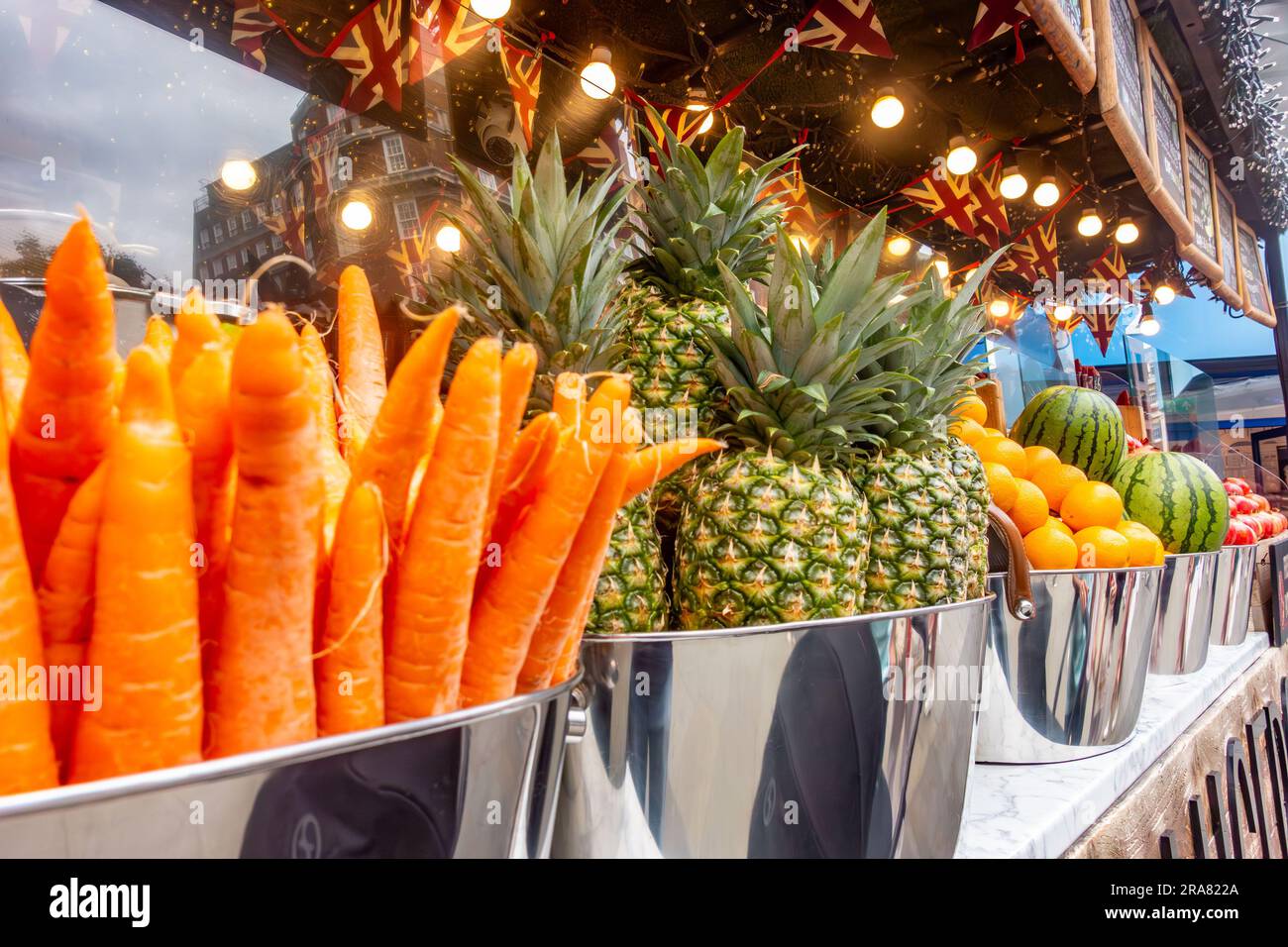 Fresh fruit and vegetables displayed along the front of a juice bar
