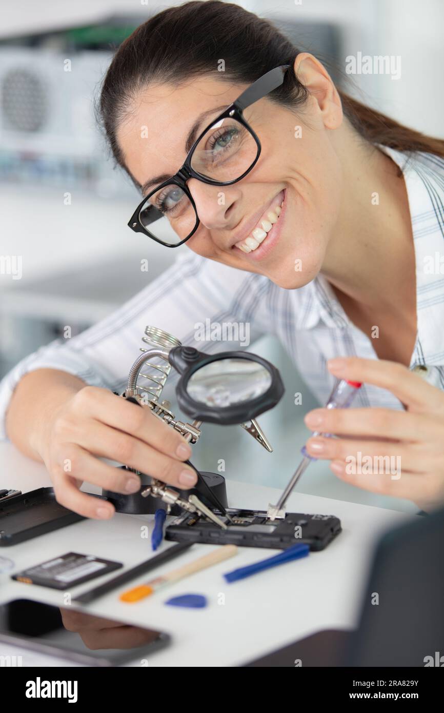 engineer woman repairs laptop support fixing notebook computer Stock Photo
