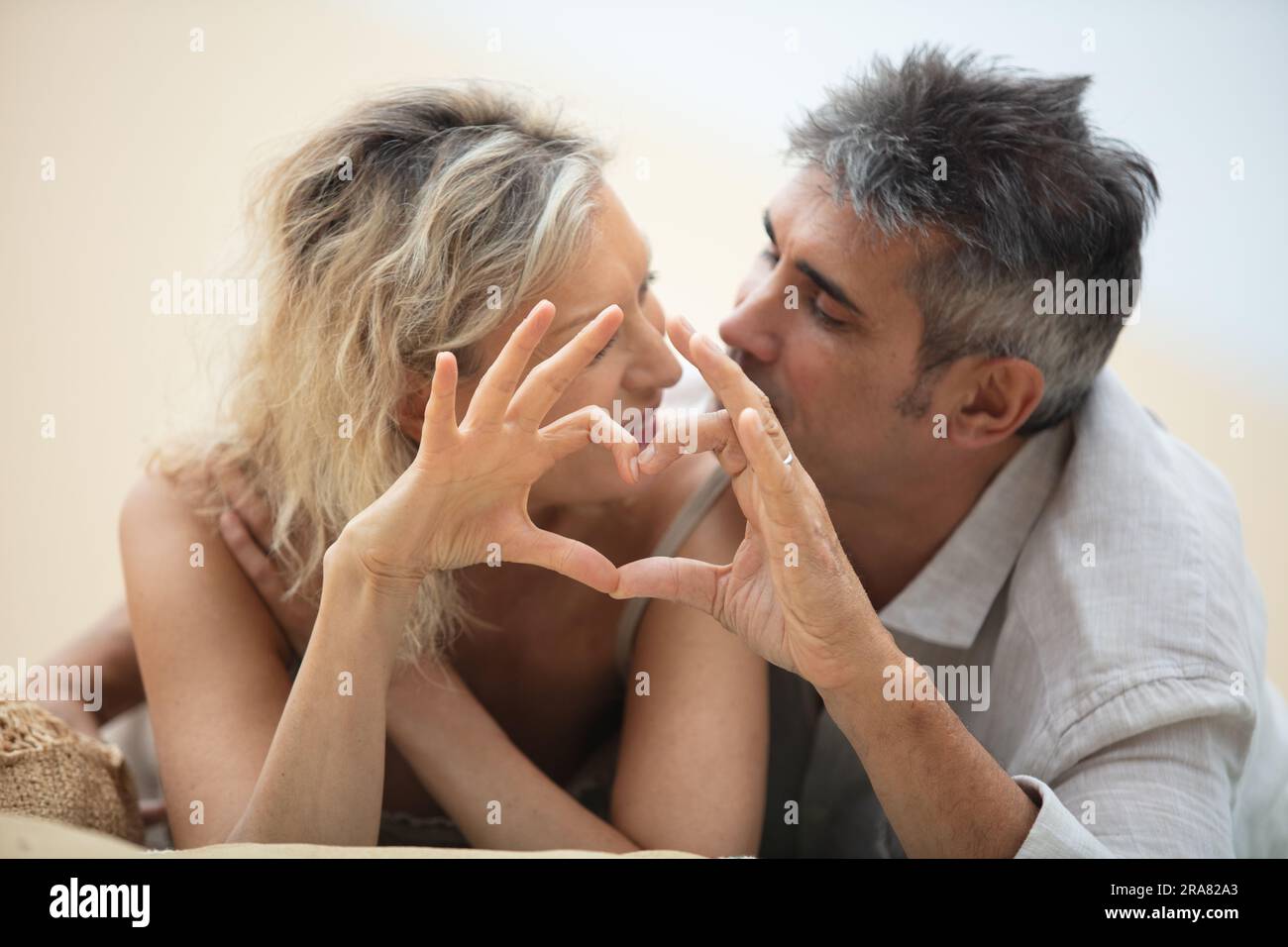 happy mature couple making heart with their hands at sea Stock Photo ...