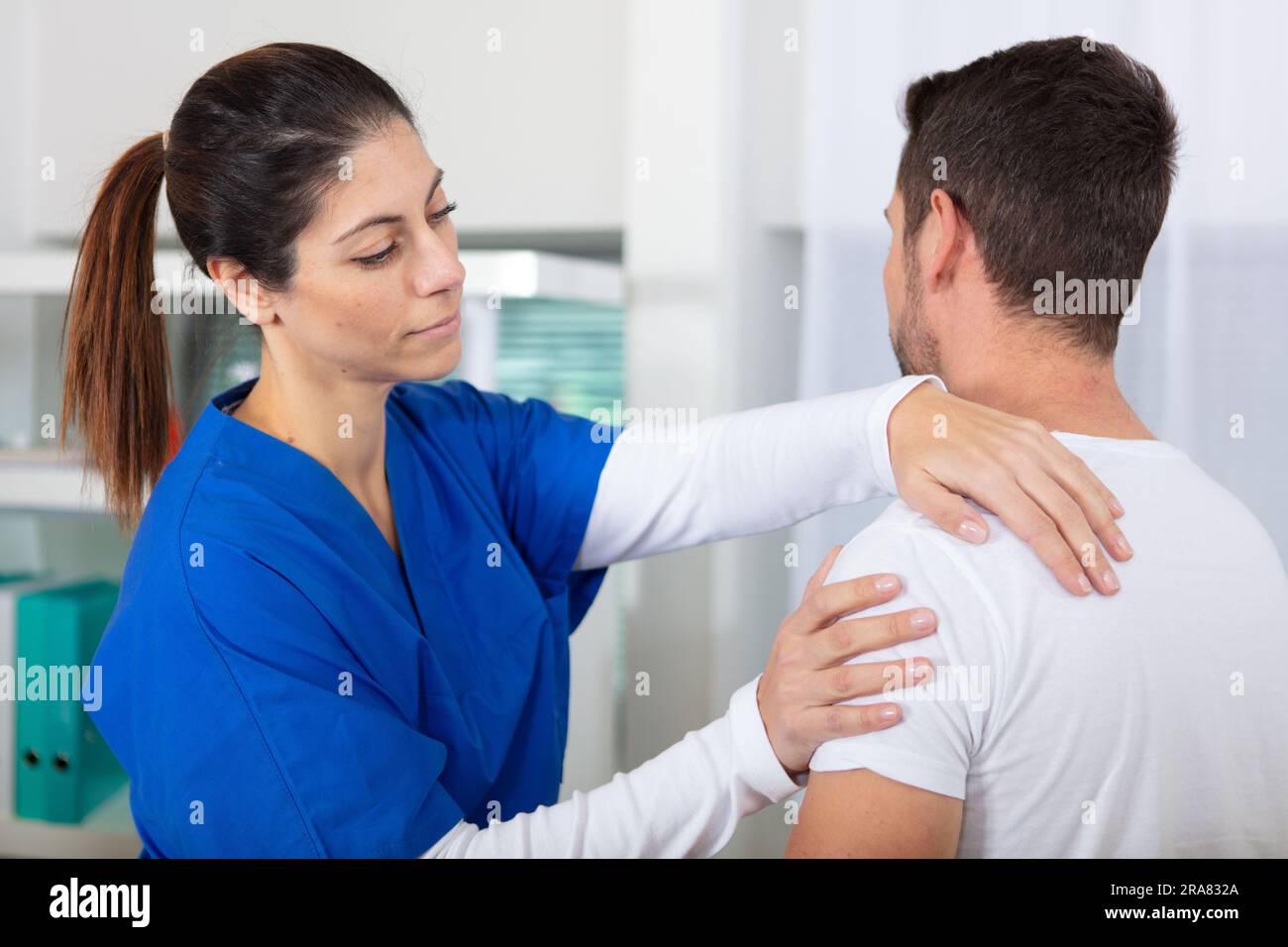 female chiropractic doctor examining injured shoulder of patient Stock ...