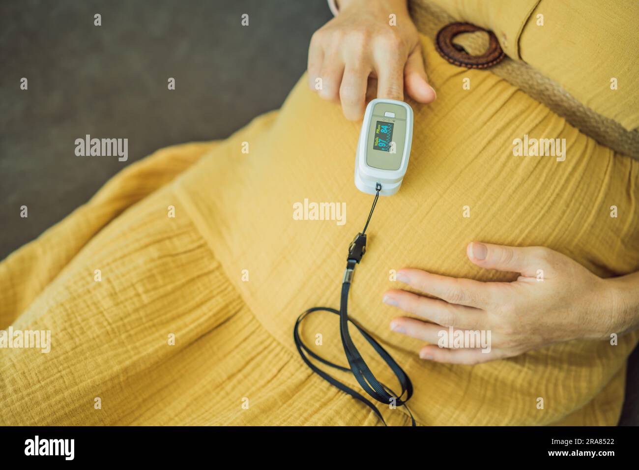 Pregnant woman with pulse oximeter on finger. Doctor measuring oxygen