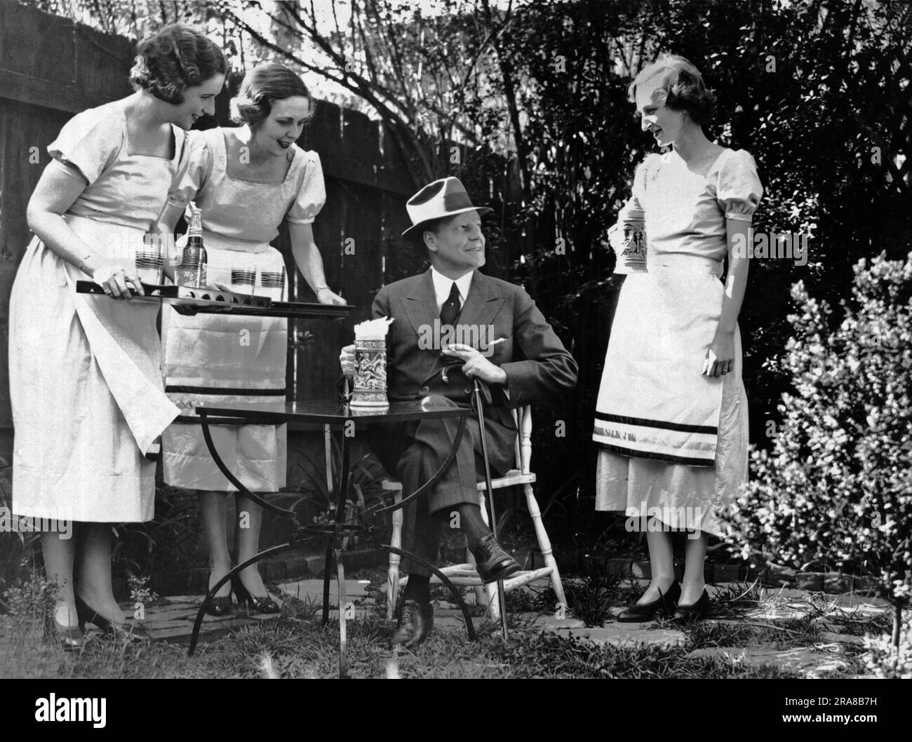 Washington D.C.:  May 4, 1933. Members of Washington's Junior League practice serving foaming steins of beer in their garden at home before serving it in the Beer Garden at the National Capital Horse Show. Prohibition will end in three days and beer will be legal. Stock Photo