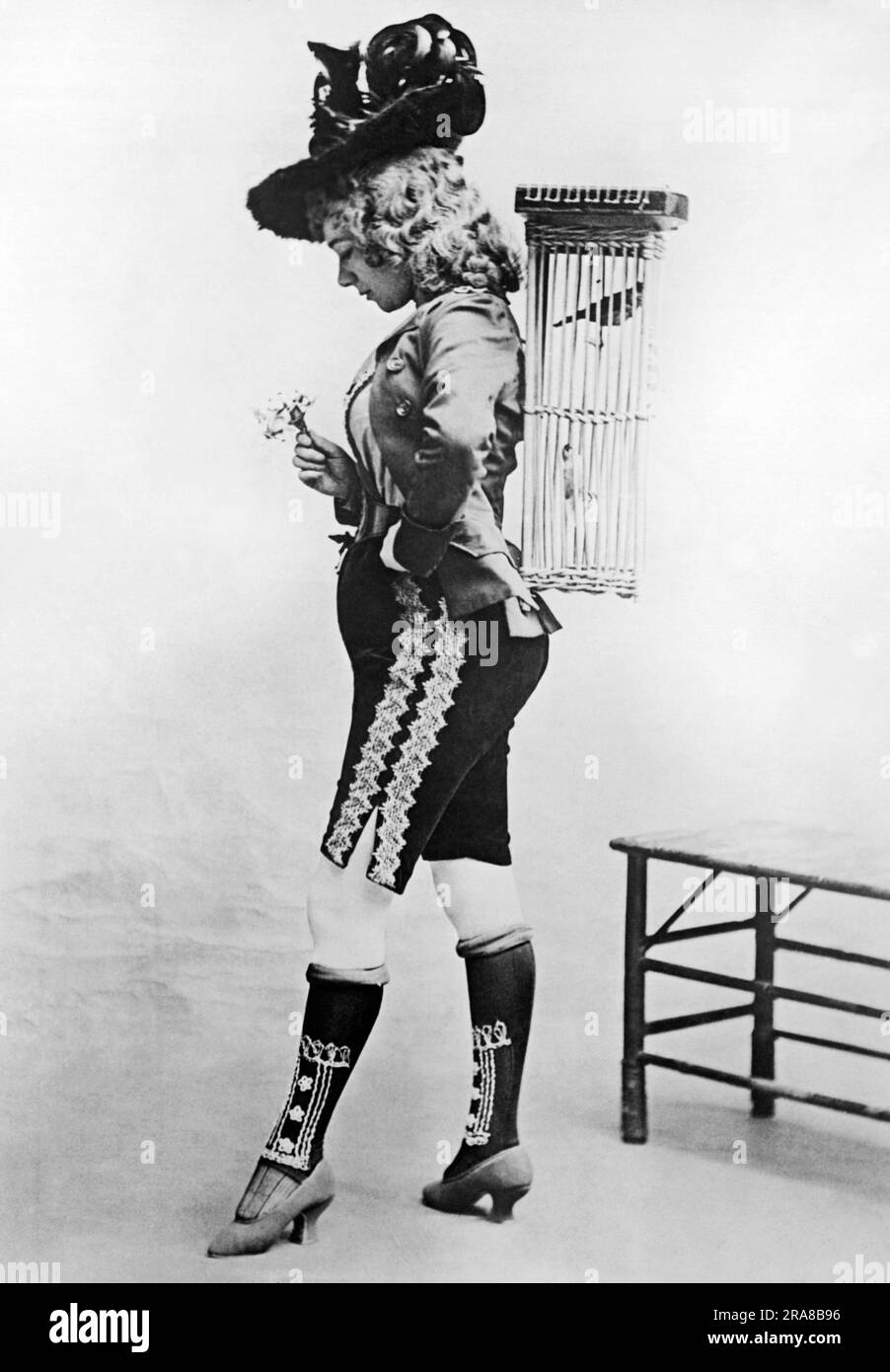 New York, New York:  1891 Noted soprano singer and actress Marie Tempest as she appeared in 'Tyrolean' on Broadway, complete with rolled stockings and a bird in a bird cage on her back. Stock Photo
