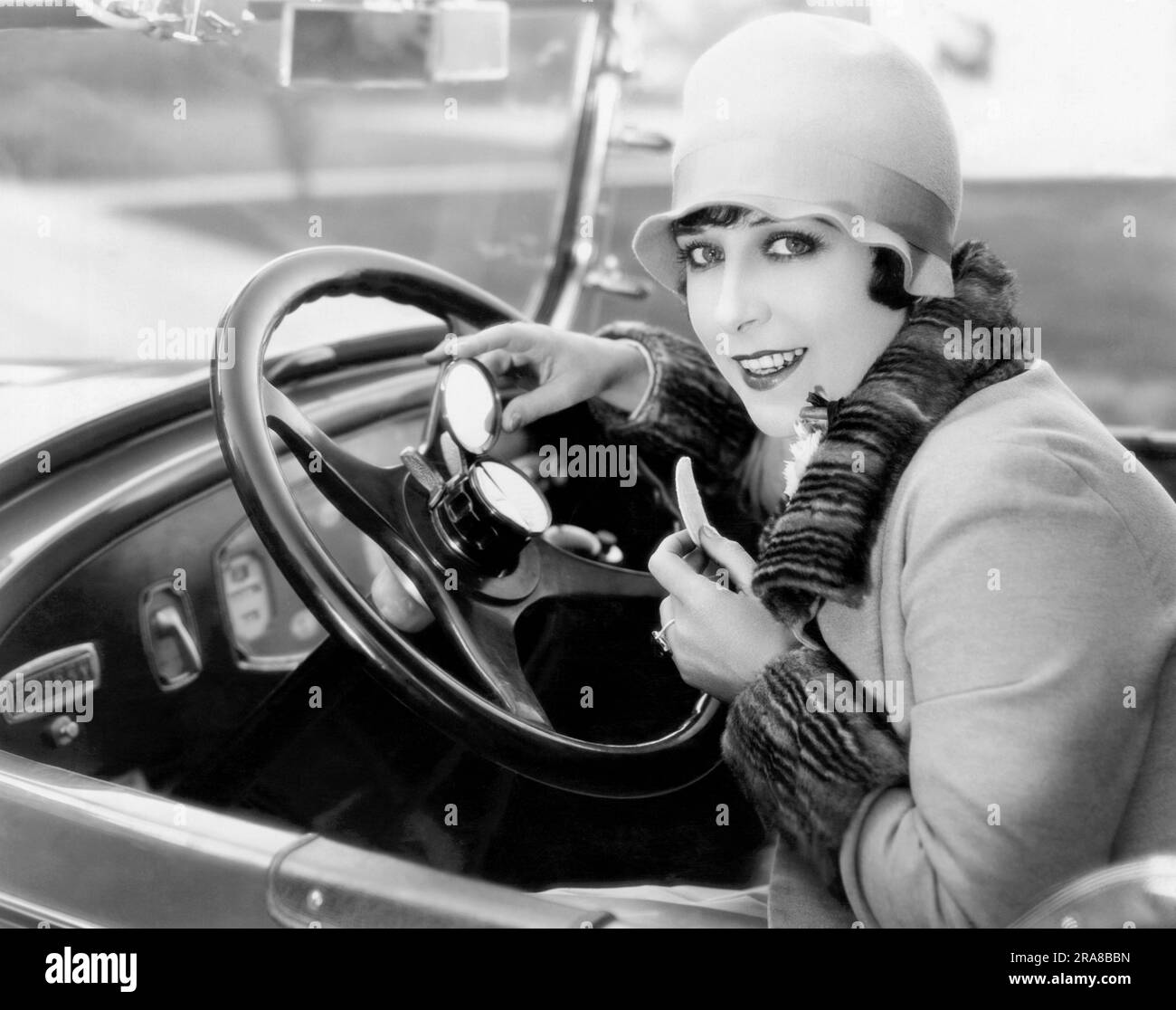 Hollywood, California:  November 17, 1926 Actress Dorothy Phillips uses her new horn button vanity case on her steering wheel. It's great for makeup on the road when you're late to the set. Stock Photo