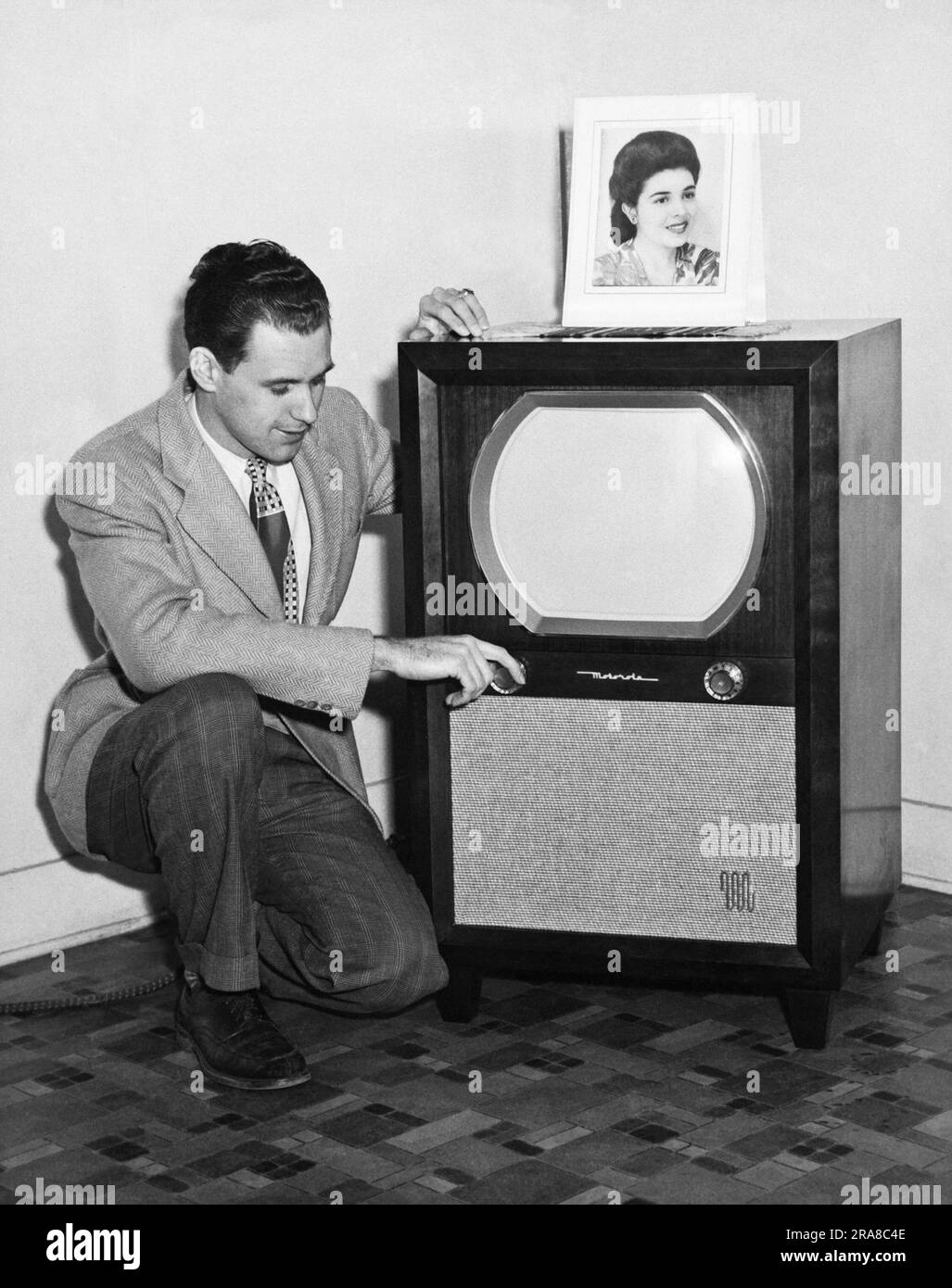 United States:  c. 1955 A man adjusting his Motorola television set. Stock Photo