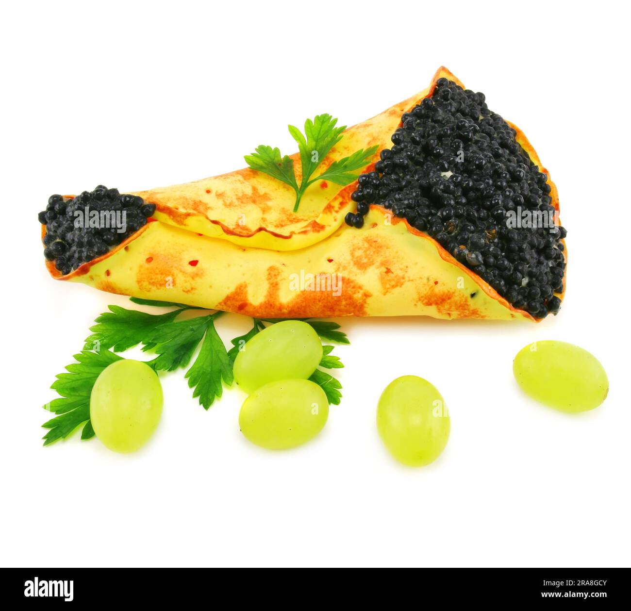 Caviar-stuffed pancake and grapes isolated on a white background Stock Photo