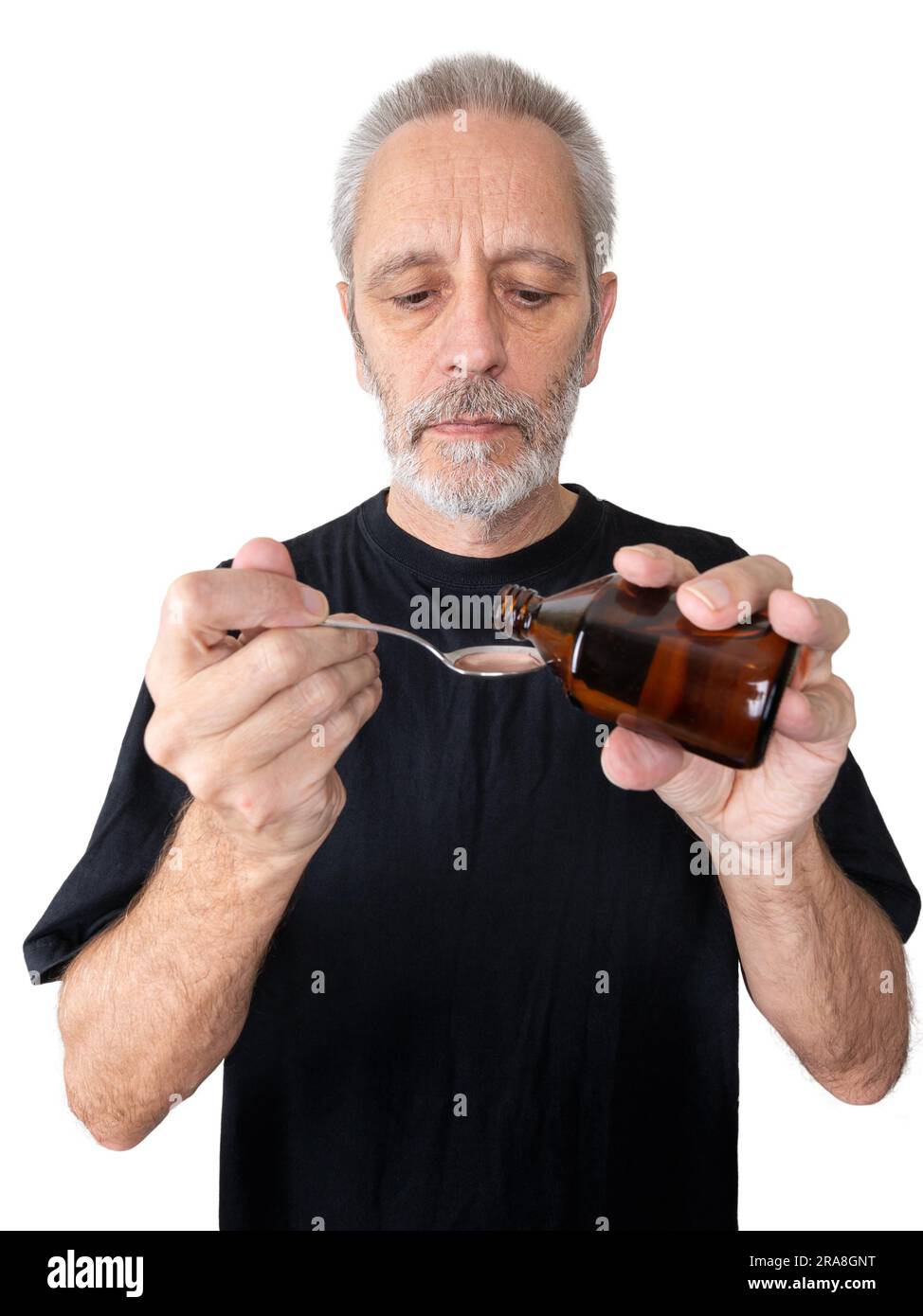 A mature man is pouring cough syrup in a spoon to cure his sore throat