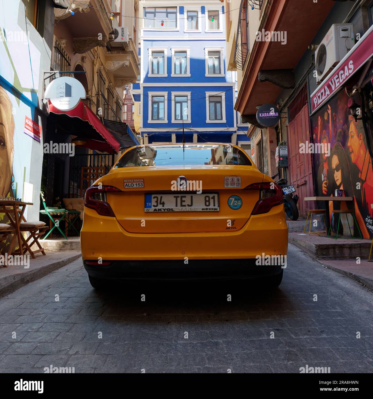 Yellow taxi parked on a colourful street in the Cihangir neighbourhood of Istanbul, Turkey. Stock Photo