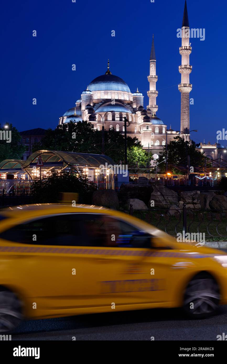 Yeni Cami Mosque on a summers night with a yellow taxi in foreground blurred by motion. Istanbul, Turkey Stock Photo