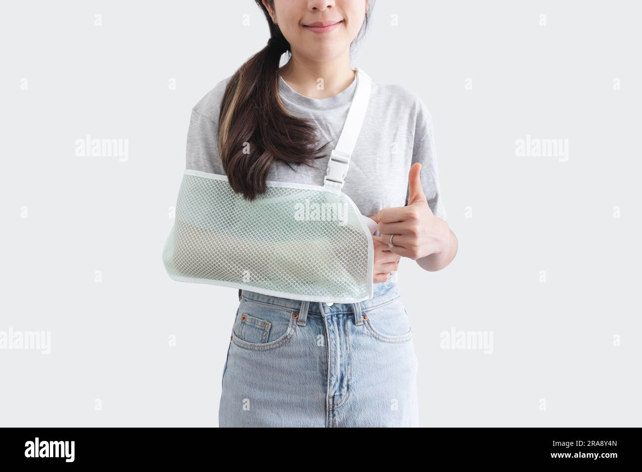 Young woman with hand injured wearing splint, broken arm, showing thumb