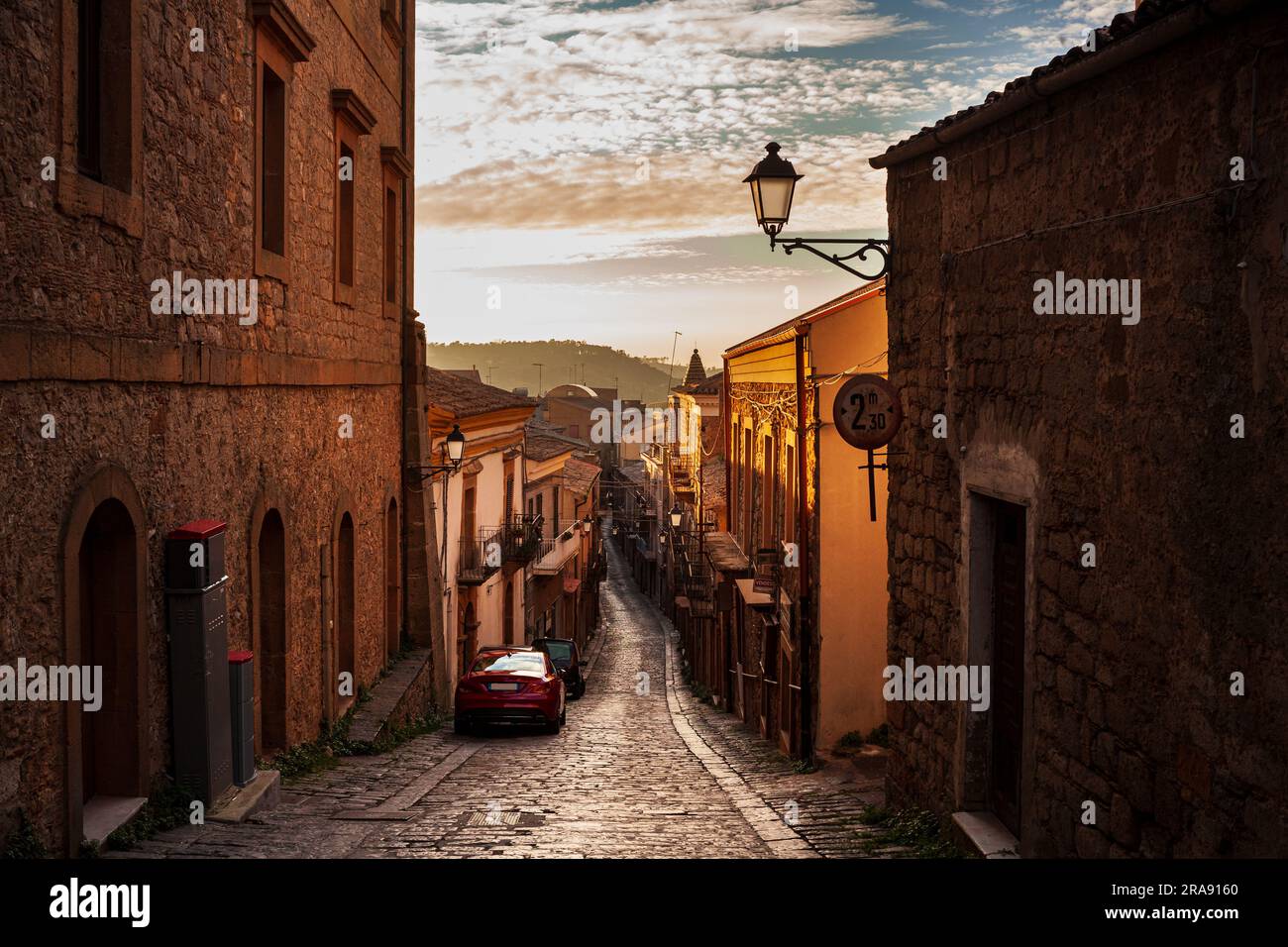 Street with old houses of Aidone at sunset in the Enna province, Sicily in Italy Stock Photo