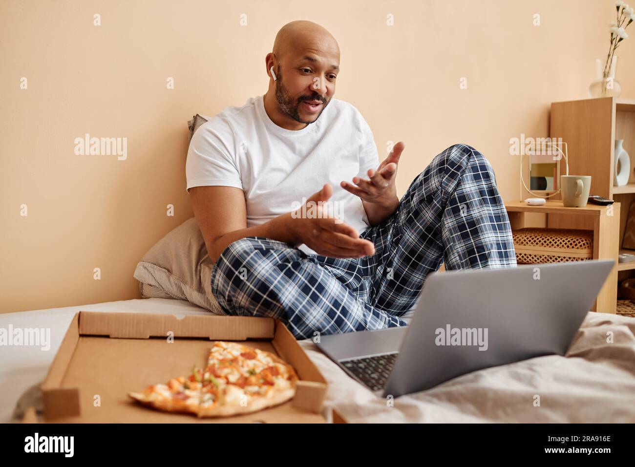 Portrait of black man enjoying laze weekend at home and talking via video chat, copy space Stock Photo