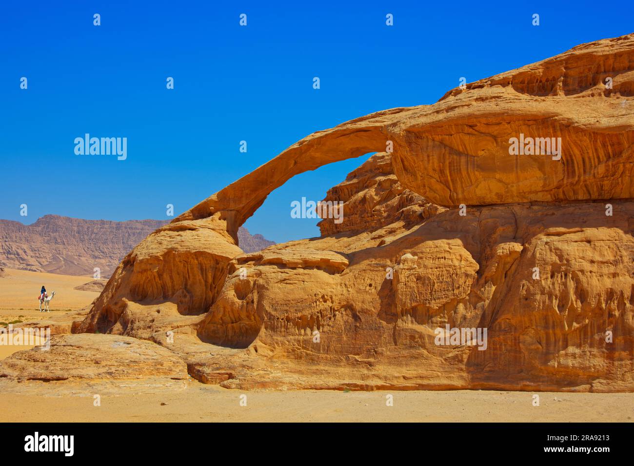A SUV car crossing the desert with yellow sand on a hot day under the blue sky Stock Photo