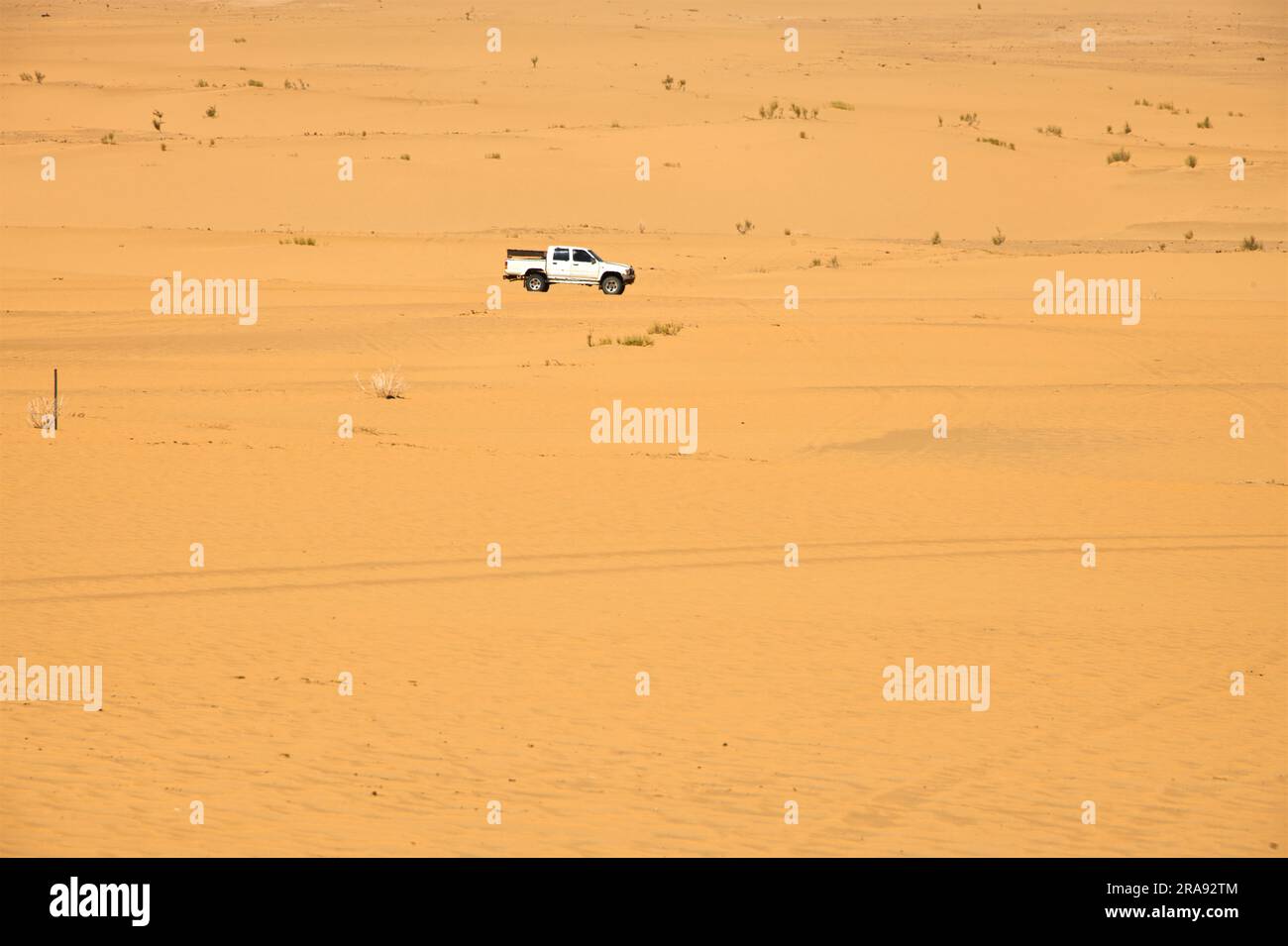 A SUV car crossing the desert with yellow sand on a hot day Stock Photo