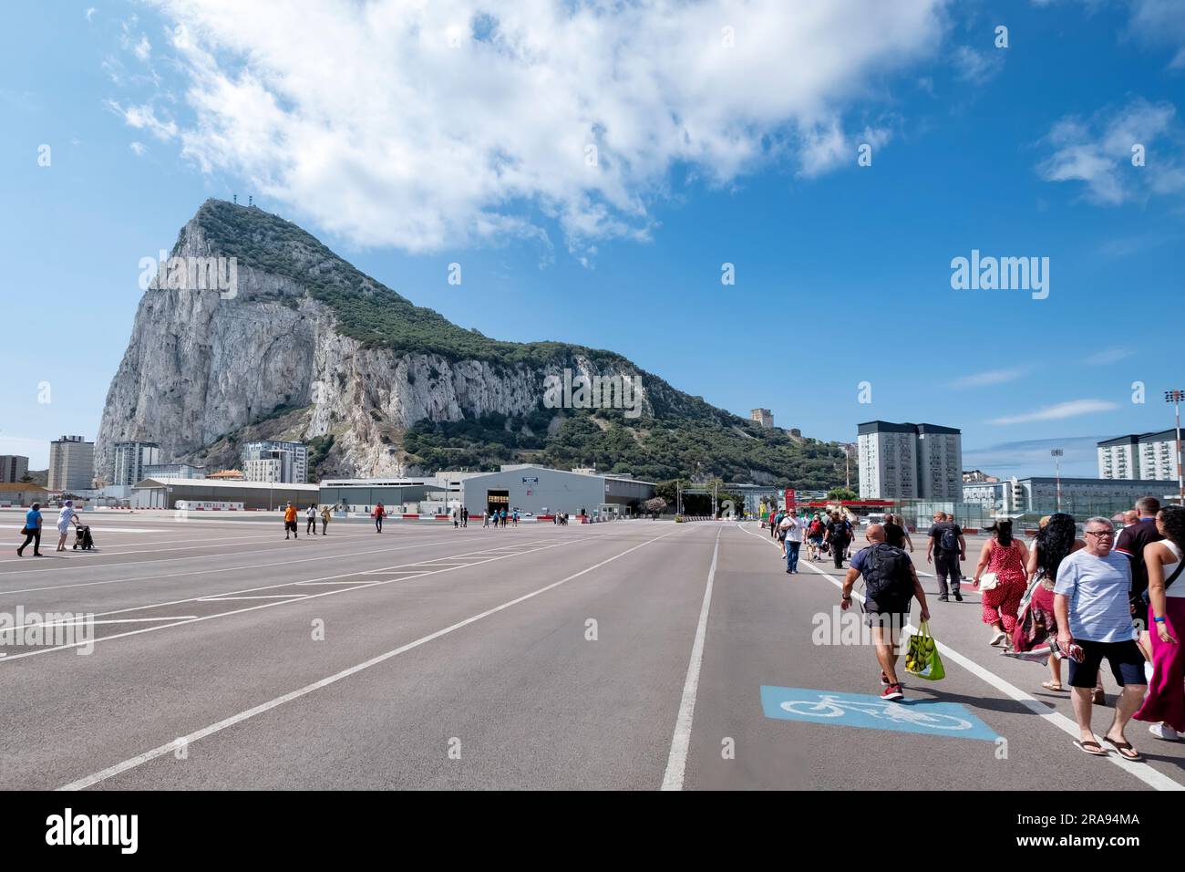 Tourists and Spanish workers walking across the airport runway, Winston Churchill Avenue, into Gibraltar from the Spanish border point. Stock Photo