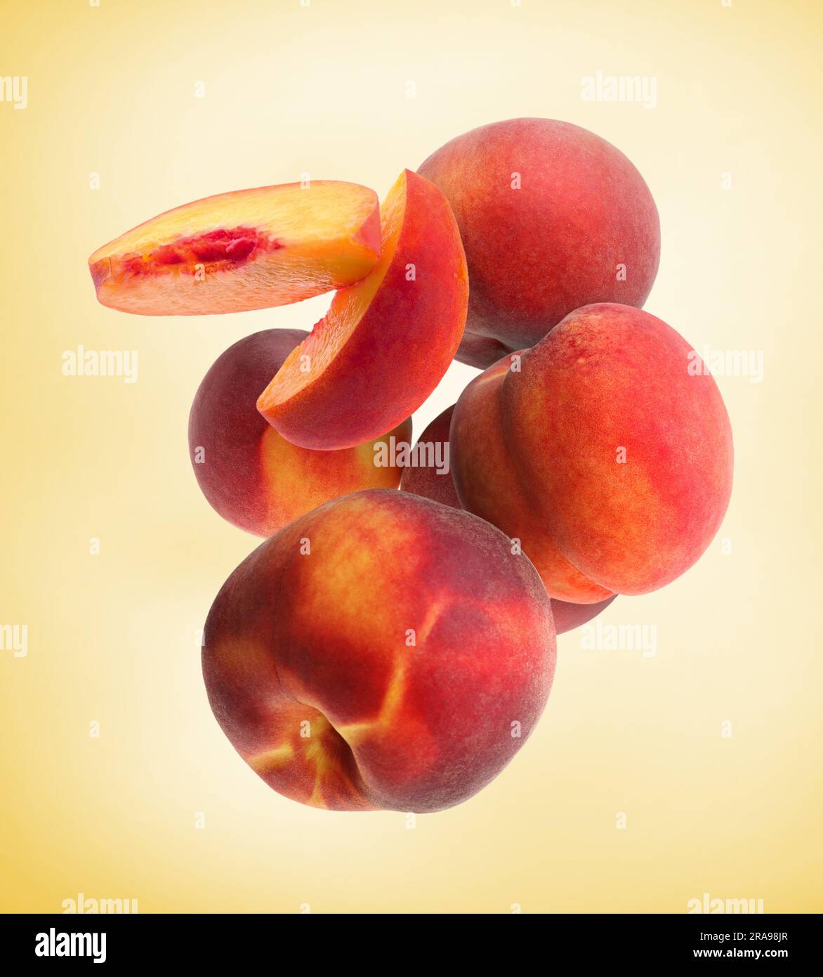 Cut and whole fresh ripe peaches falling on pale gold background Stock ...