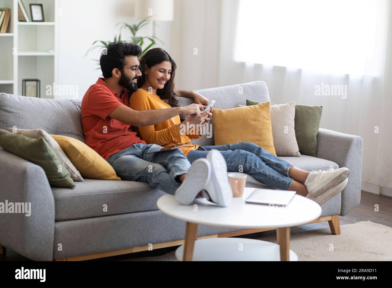 Beautiful Young Indian Couple Using Mobile Phone And Embracing Together ...