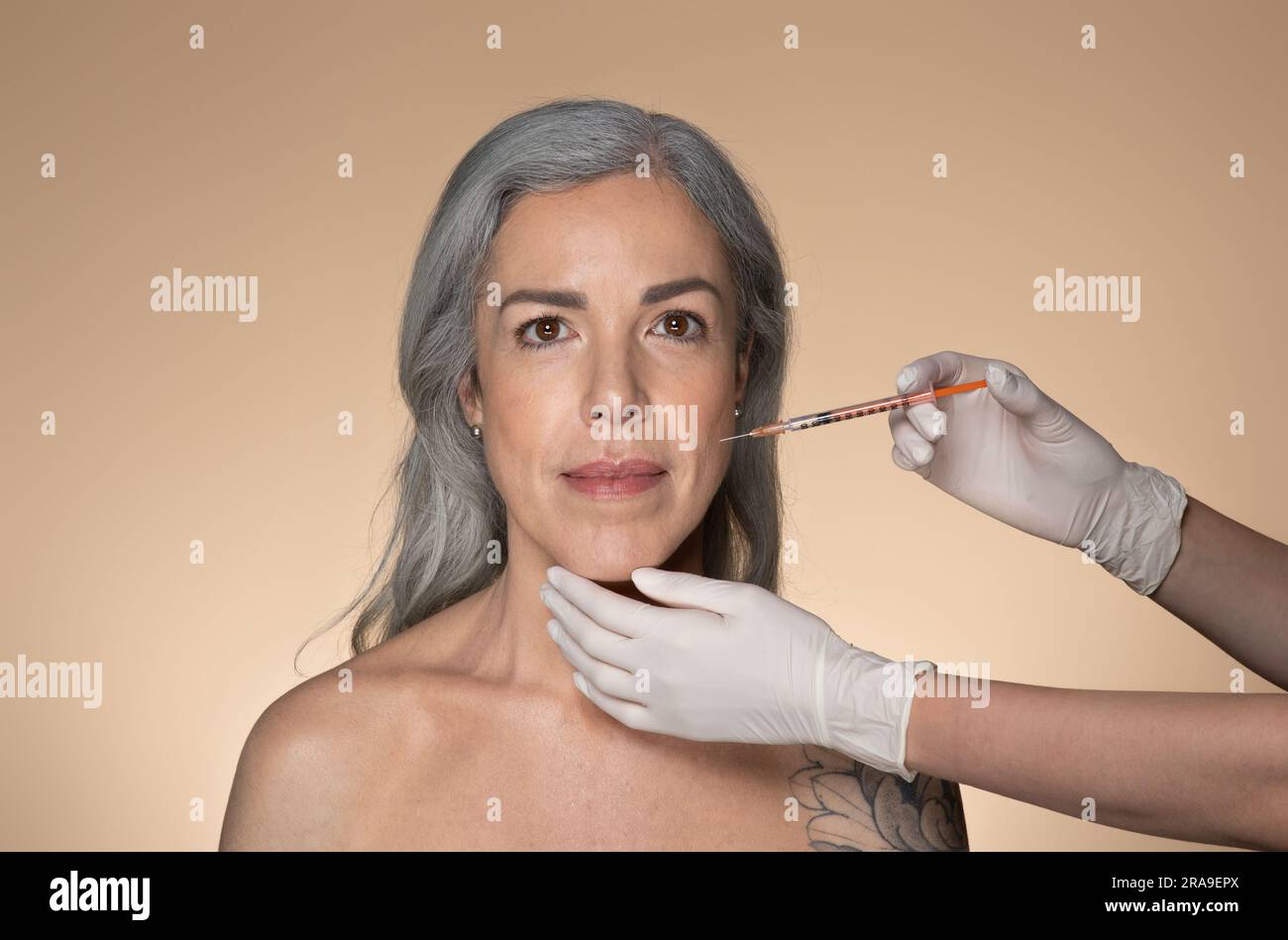 Attractive senior grey-haired woman getting cosmetic injection in ...