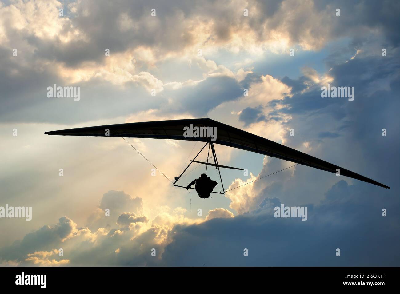 Real racing sport hang glider silhouette with dramatic sky on the background. Stock Photo