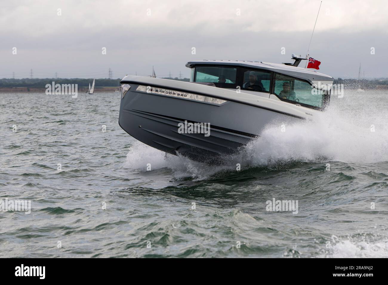 Smart and fast Saxdor 320 GTC motor boat makes light work of the choppy water as it cruises down Southampton Water on the South coast of England Stock Photo