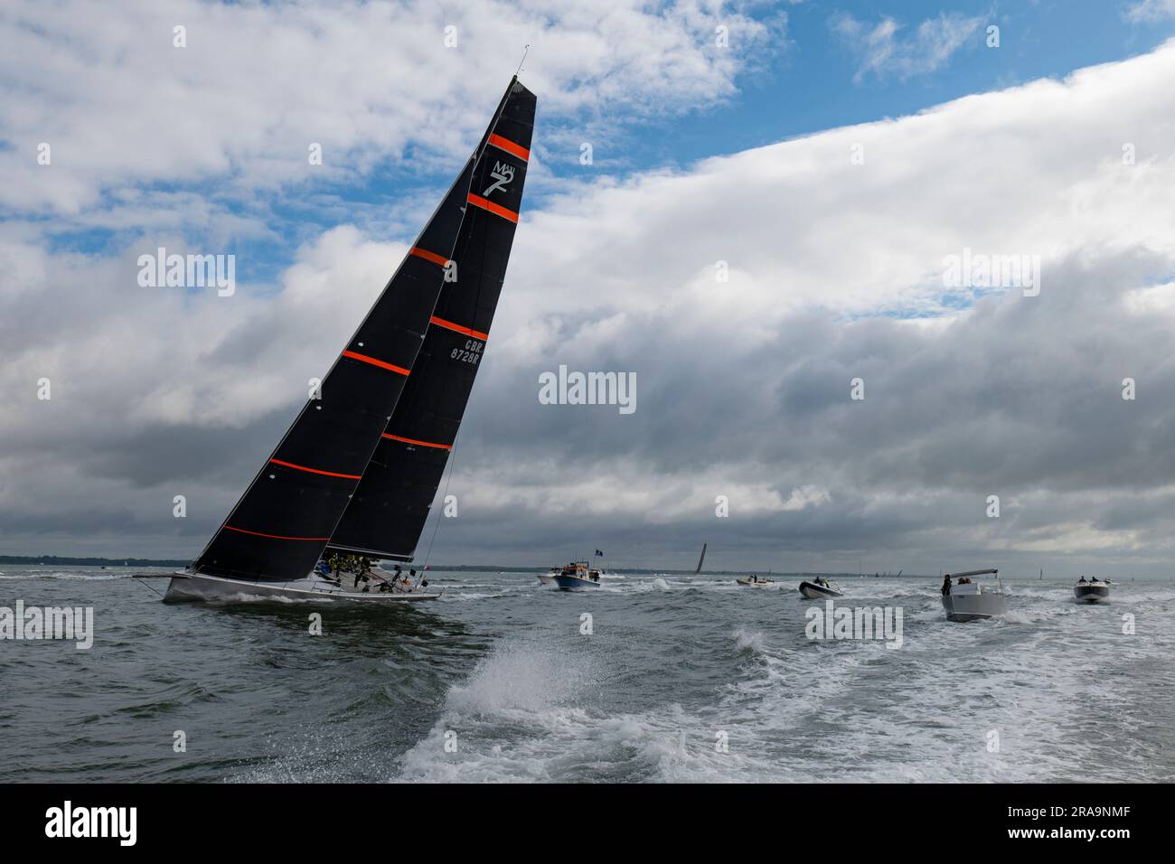 Notorious a Maxi 72 Racing Yacht powers up the Solent with chase boats following on her way to a fantastic 2nd position in the Round The Island Race Stock Photo