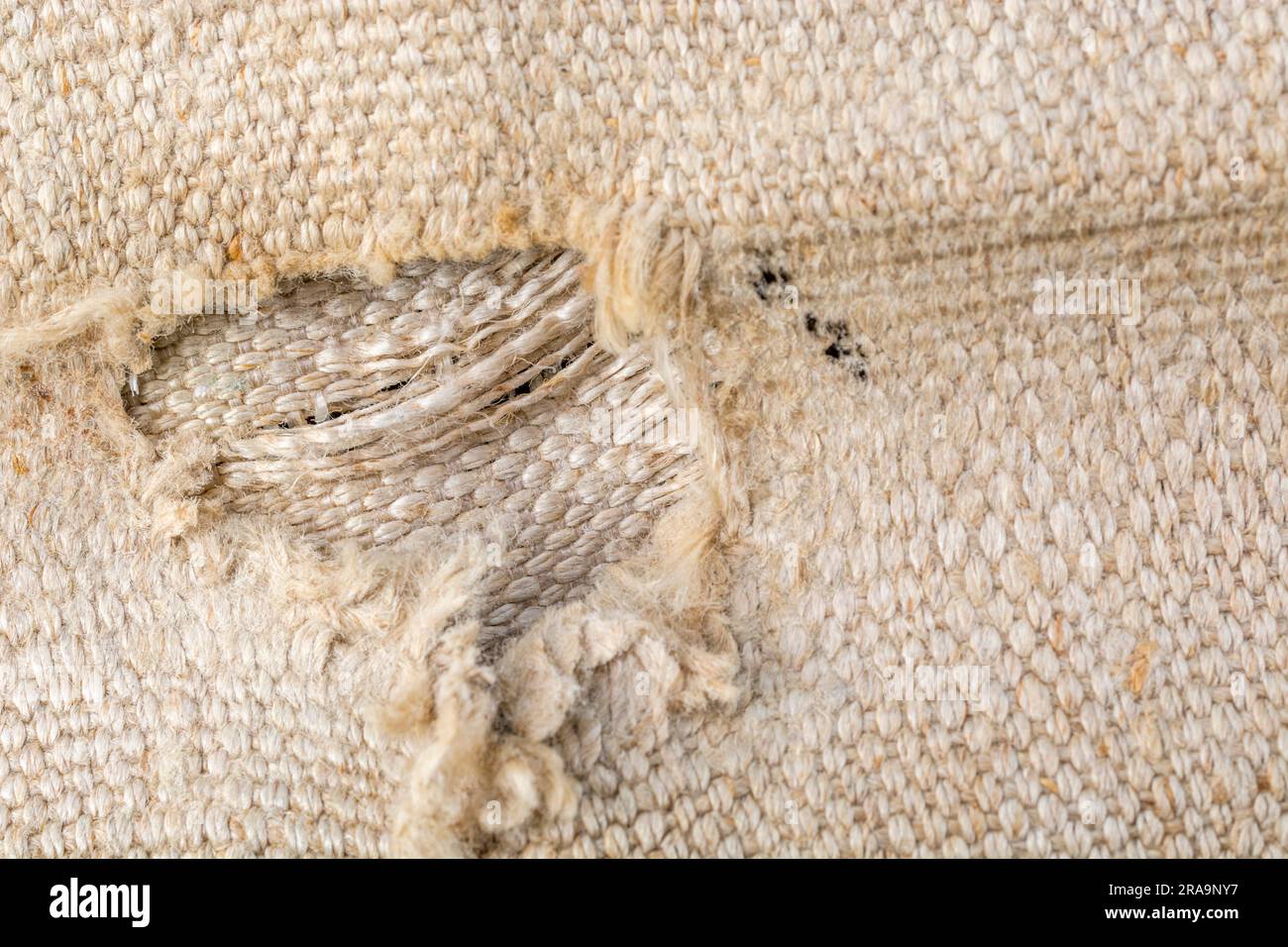 Close-up shot of worn seat fabric Appears to be mixed fibre not 100% cotton. For frayed edges, seen better days, out of condition metaphor. Stock Photo