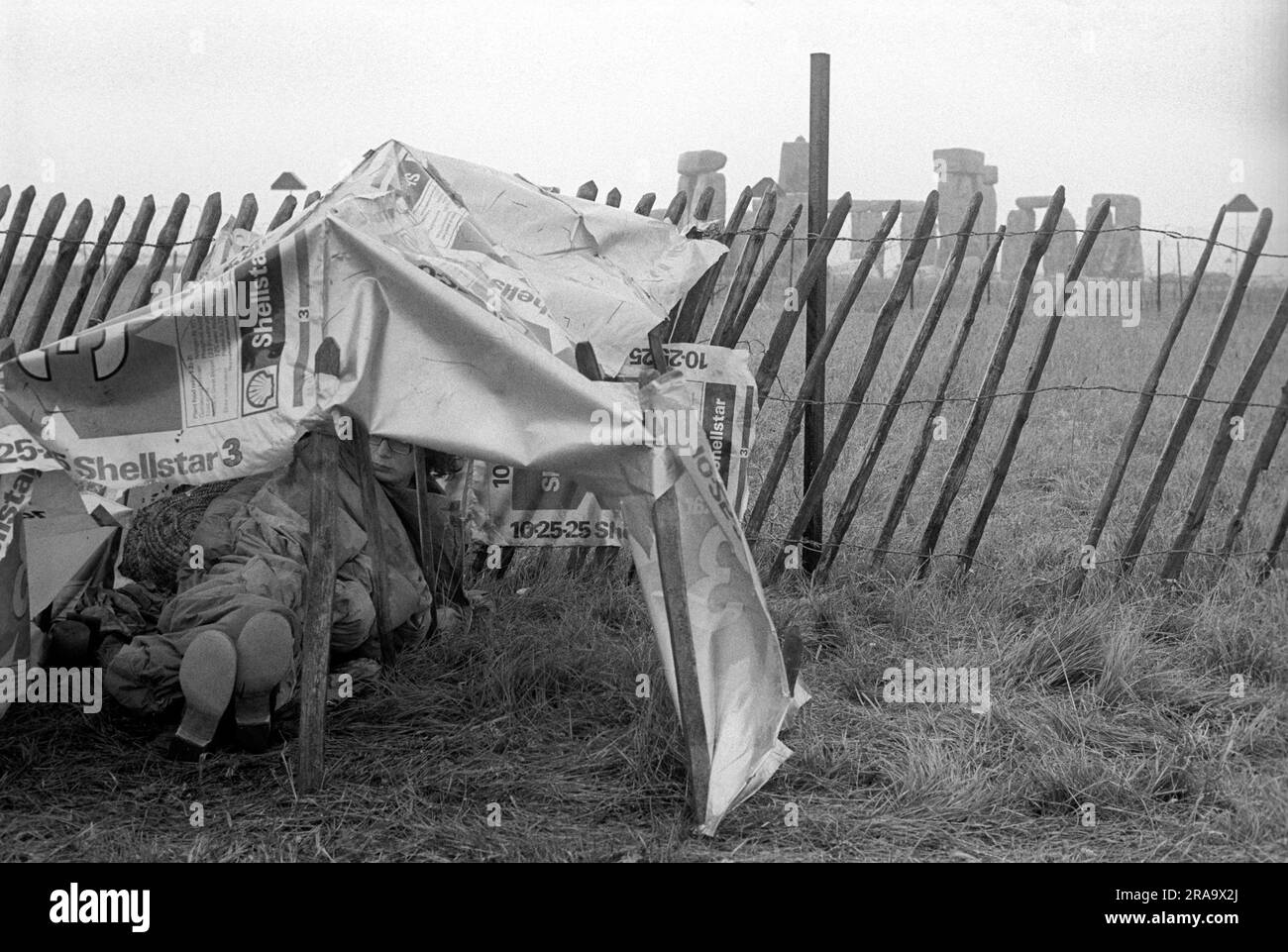 Stonehenge Free Festival at the summer solstice, Wiltshire, England circa June 1976. Festival goers try and keep warm and dry in their makeshift tent. 1970s UK HOMER SYKES Stock Photo