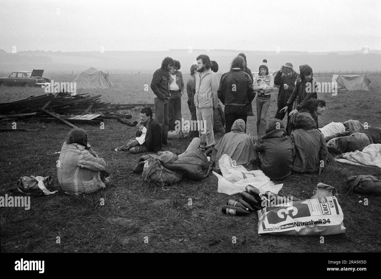 Stonehenge Free Festival at the summer solstice, June 21st Summer Solstice. Festival goers up all night, wet and cold one early morning. Wiltshire, England circa June 1976. 1970s UK HOMER SYKES Stock Photo