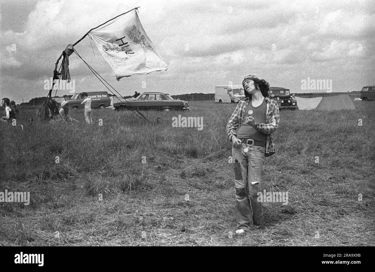 Playing air guitar. Stonehenge Free Festival at the summer solstice, Wiltshire, England circa June 1976. A young hippy playing air guitar and getting into the music. 1970s UK HOMER SYKES Stock Photo