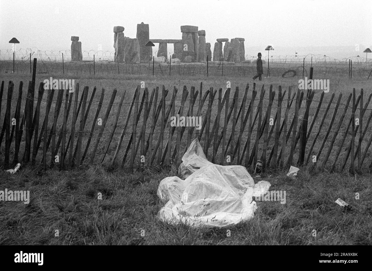 Summer rain a hippy sleeps in a make shift waterproof sleeping bag. Stonehenge Free Festival at the summer solstice, Wiltshire, England circa June 1976.  1970s UK HOMER SYKES Stock Photo