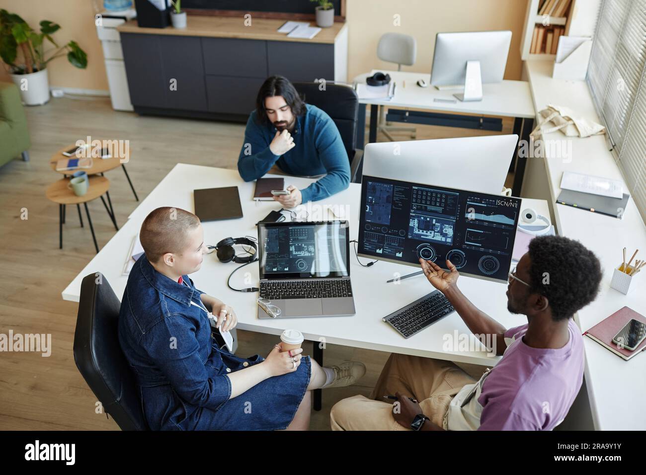 ABove view of young woman listening to her colleague explanation of ...