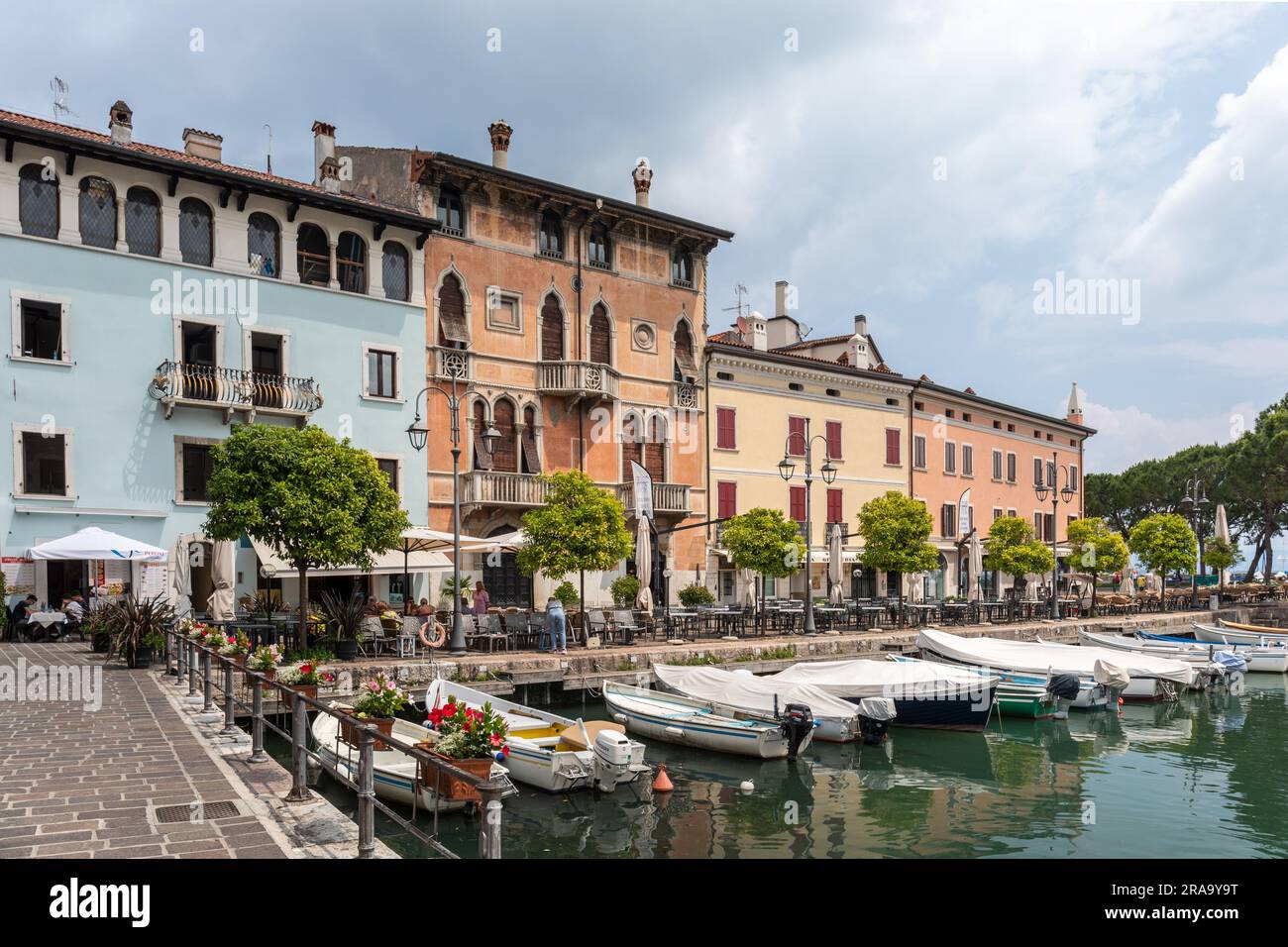 Little harbour called the old harbour lined with street cafes and restaurants, Desenzano, Lake Garda, Italy, Europe Stock Photo