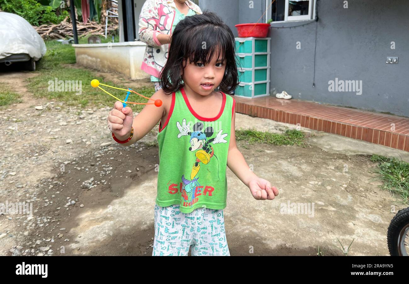 Filipino young boy playing Lato Lato in Philippines, trending toy craze