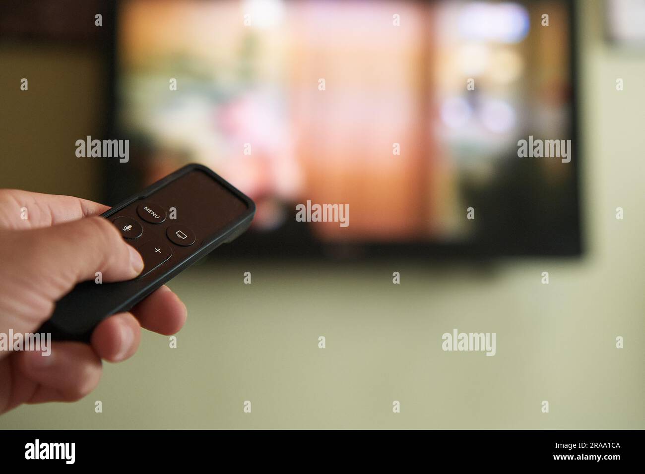 Multimedia streaming concept. Hand holding remote control. TV screen
