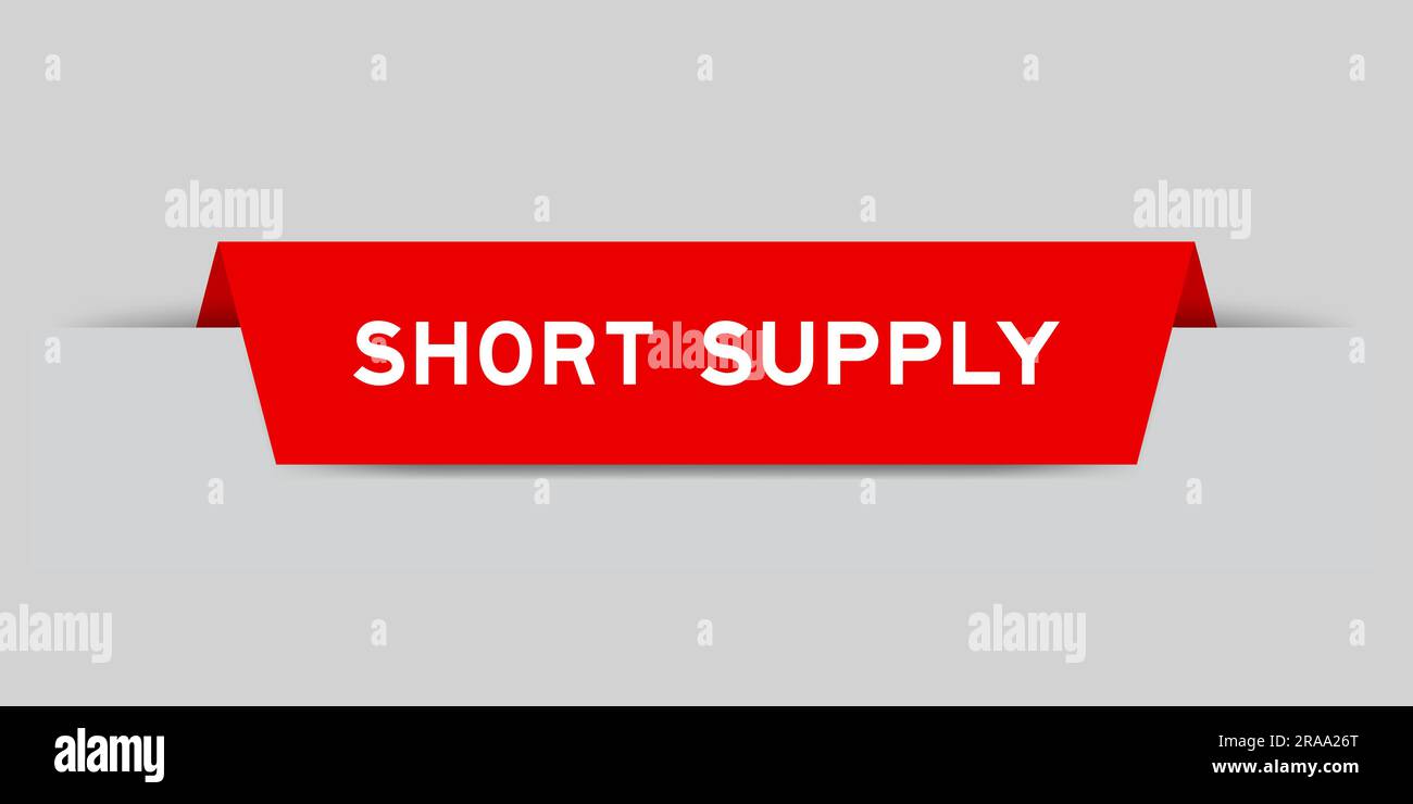 Red color inserted label with word short supply on gray background