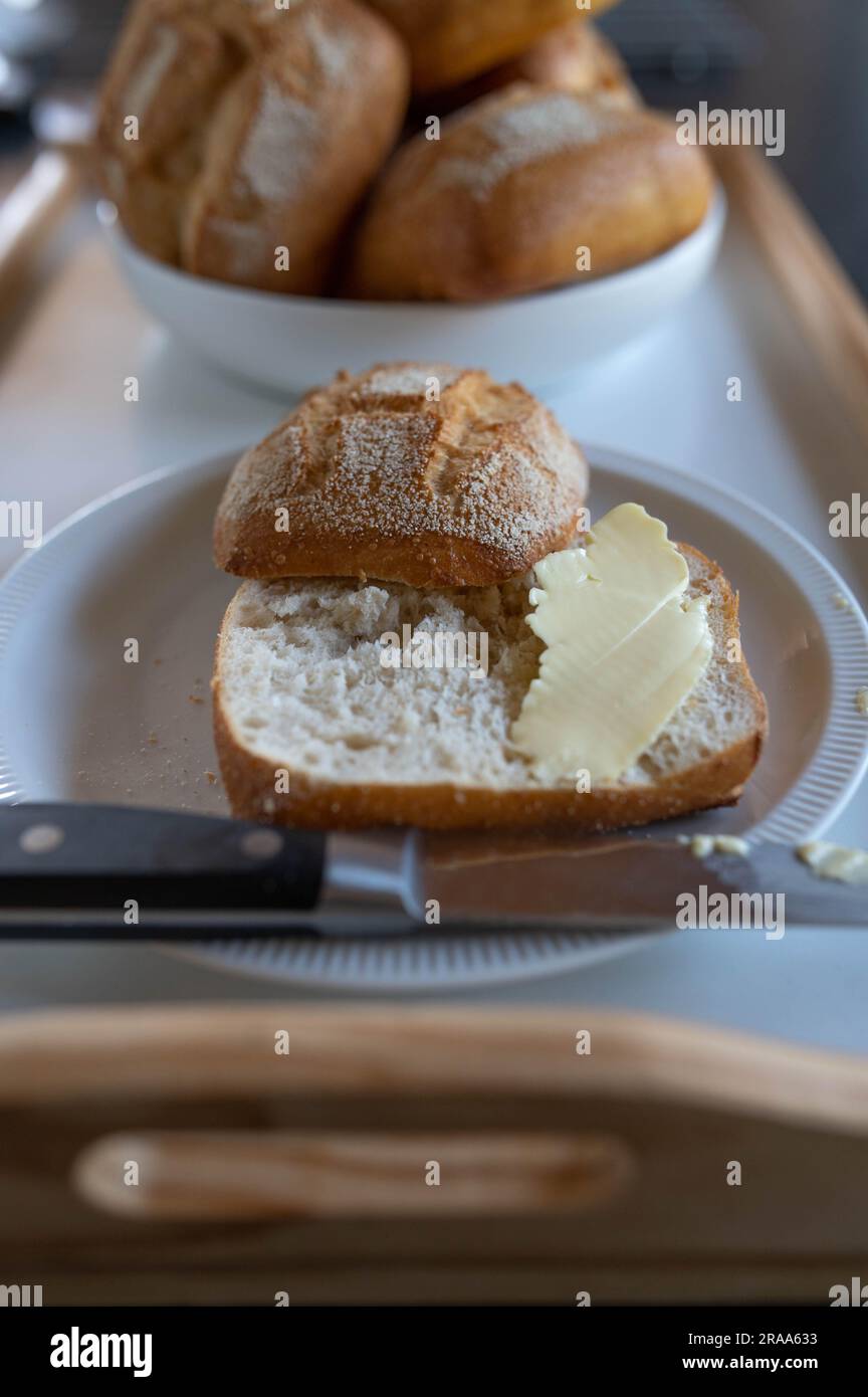 Sliced bun with butter on a plate Stock Photo
