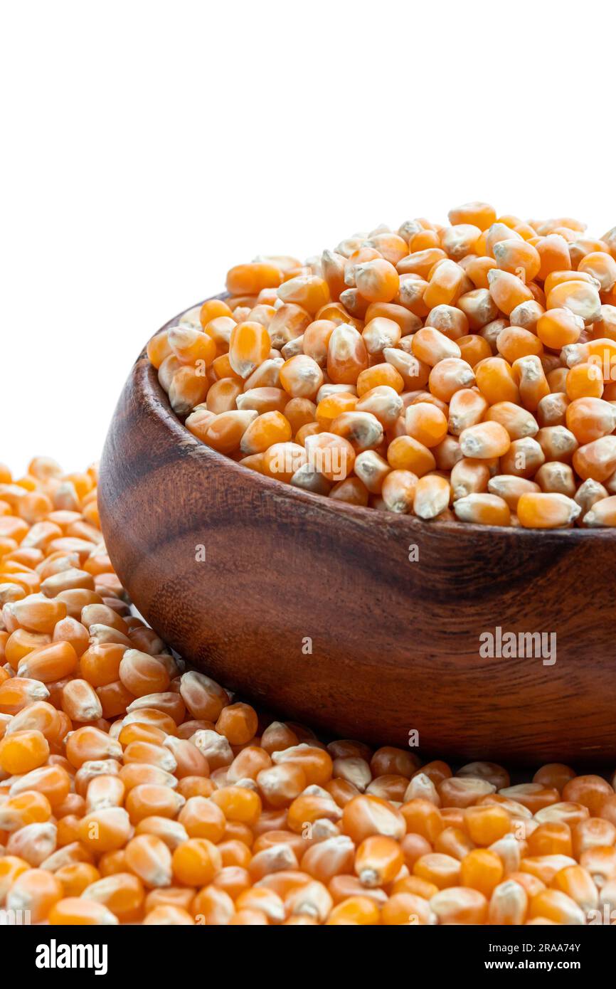 Dried  corn kernels in wooden bowl isolated on white Stock Photo