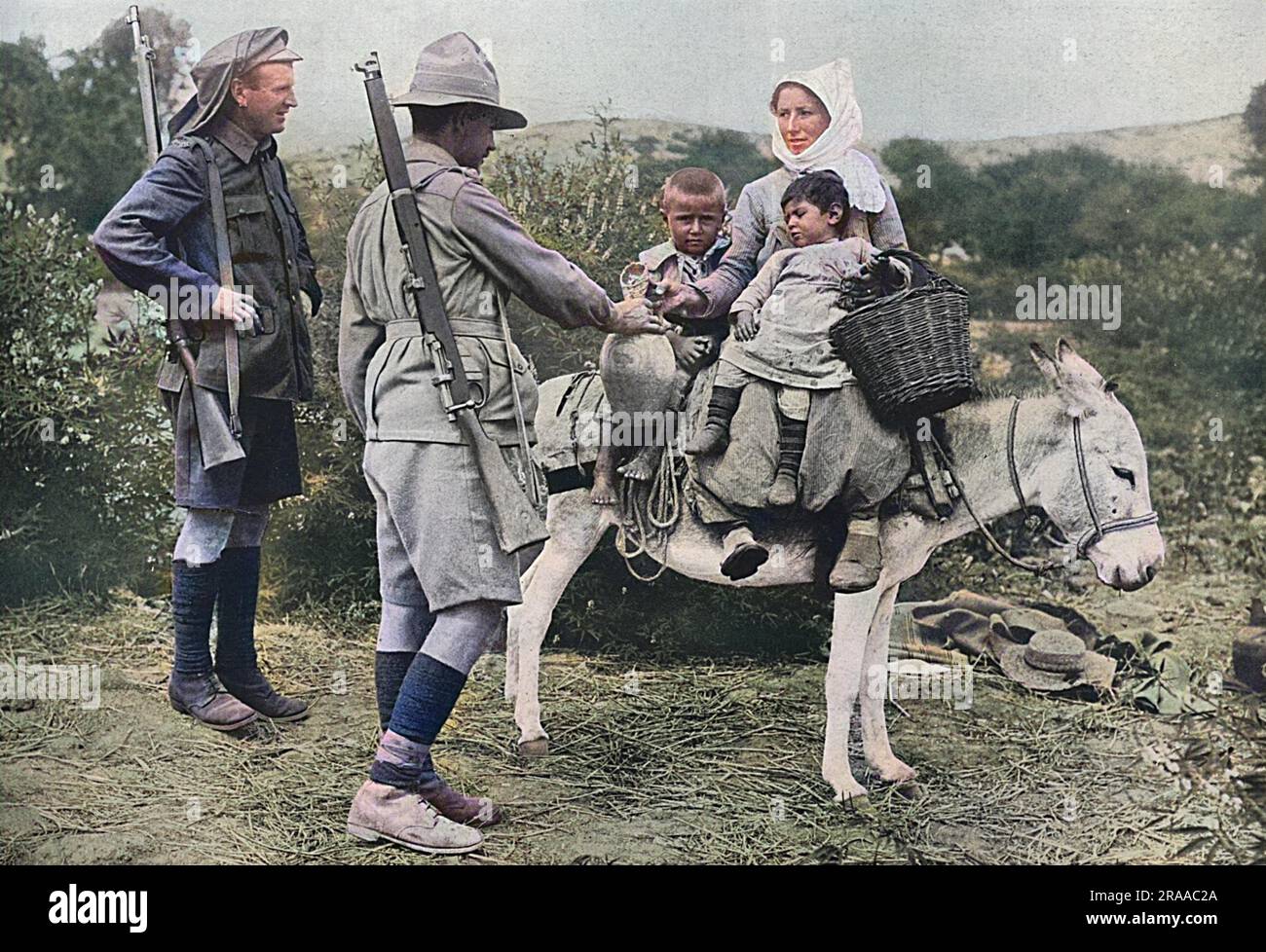 Australian soldiers pictured offering water to country children during the Dardanelles campaign of 1915.     Date: 1915 Stock Photo