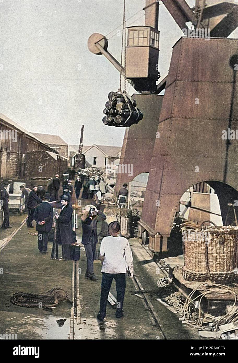 A dockyard scene during the First World War showing munitions being hoisted aboard a battleship.     Date: 1915 Stock Photo