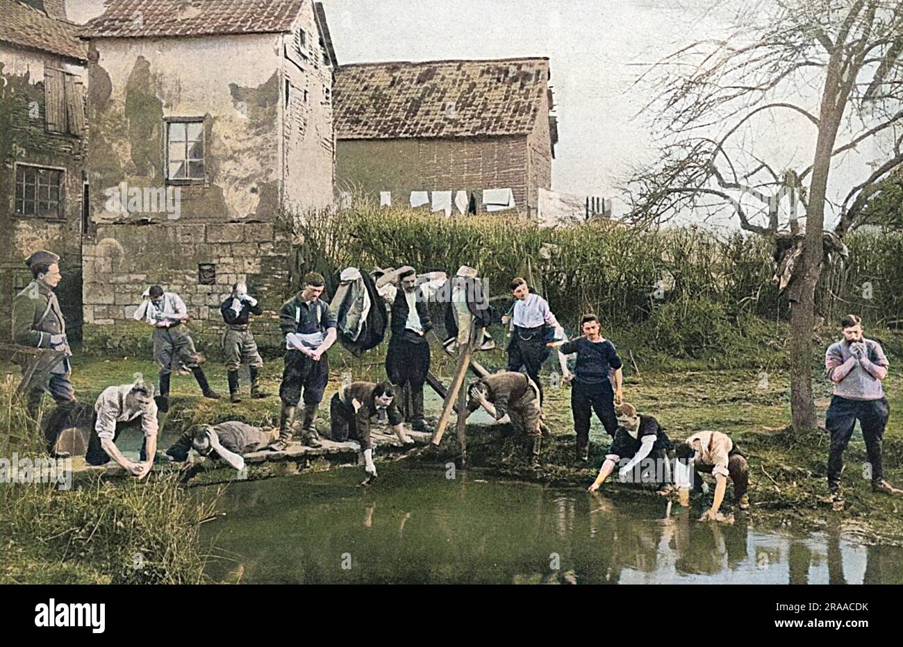 French soldiers siezing the opportunity of indulging in an al fresco wash in a village in Flanders in 1915.     Date: 1915 Stock Photo