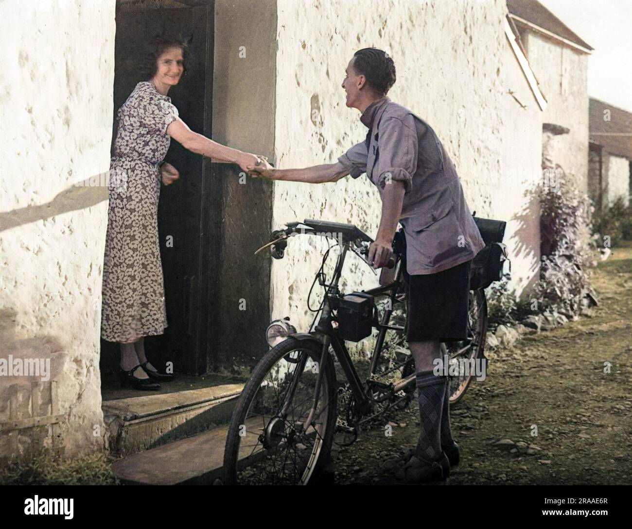 'Thanks for everything' - a tour cyclist says goodbye to the nice landlady of the bed and breakfast where he has been staying.     Date: 1930s Stock Photo