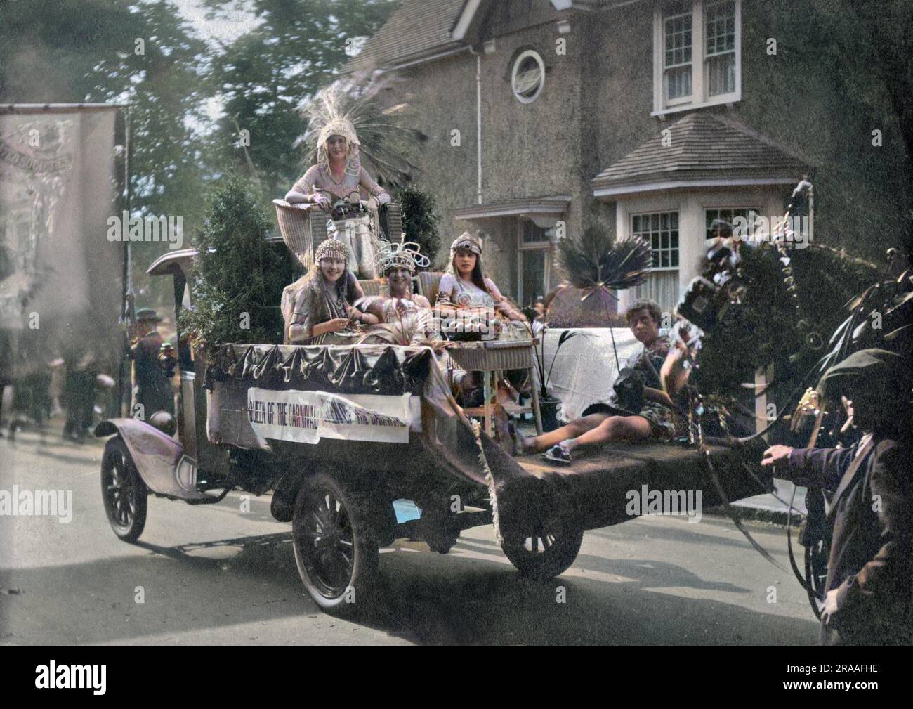 The Queen of the Carnival, dressed up to look like Cleopatra, riding along the road on the back of a truck, with four attendants. Stock Photo